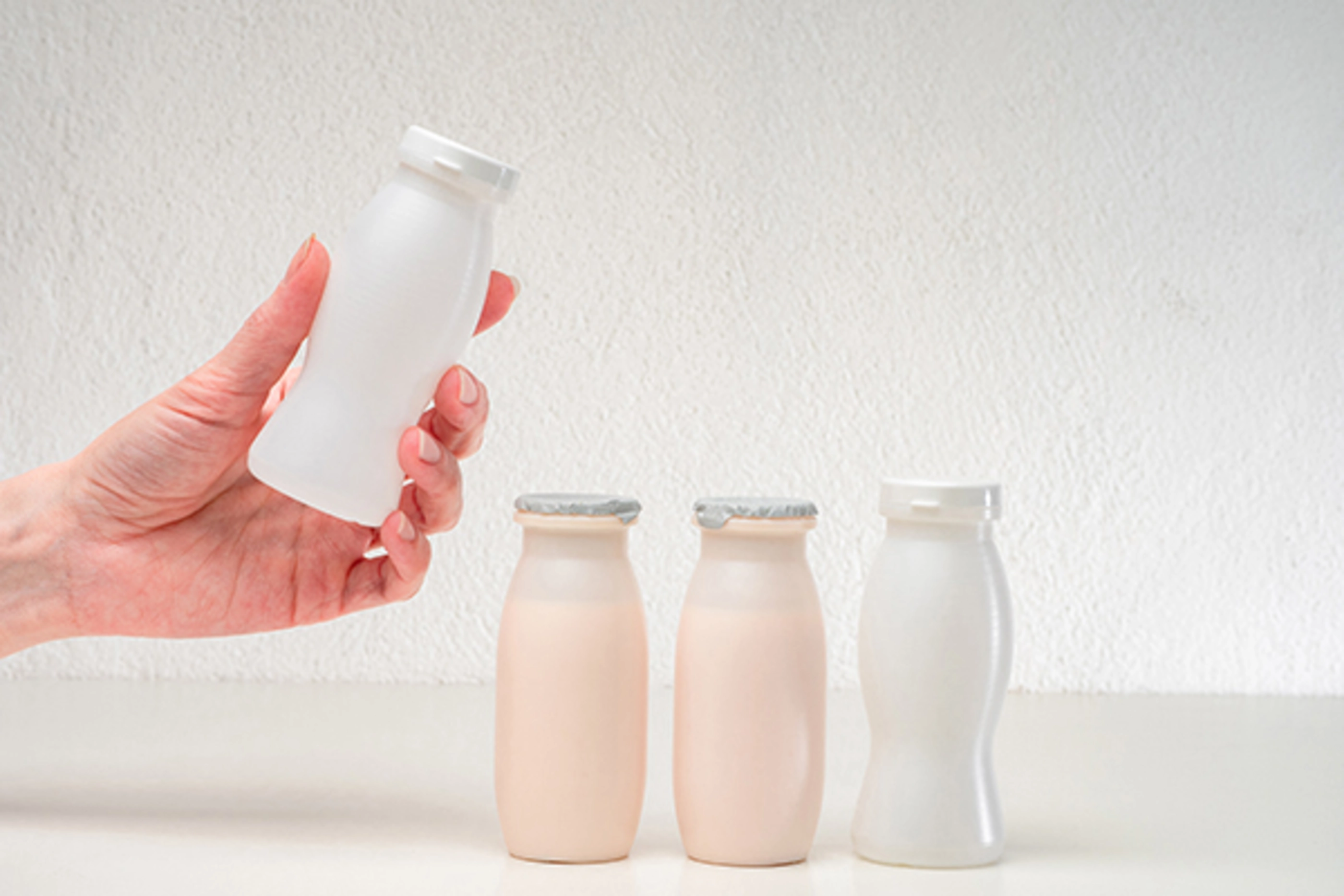 Probiotics and prebiotics. Selection of healthy food products. Dairy products on a light background. A woman chooses healthy yoghurts for her family.